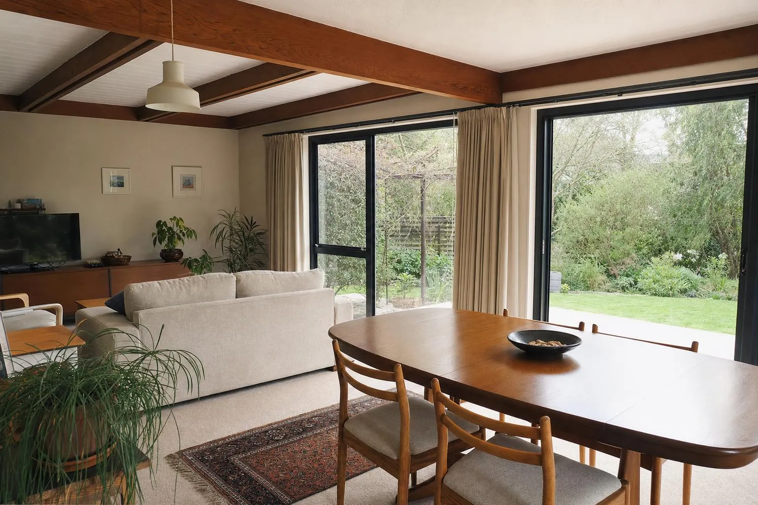 Illustrative: a 1970s living area with new charcoal aluminium windows and sliding door