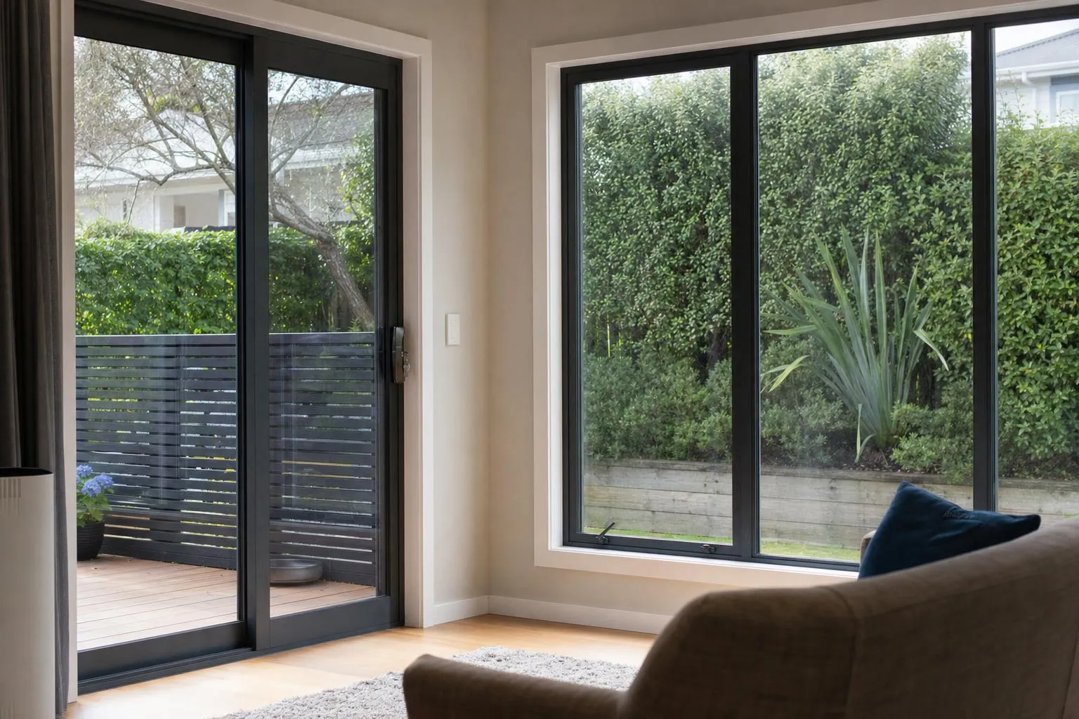 Illustrative: a family room with new charcoal aluminium windows and a sliding door onto a deck