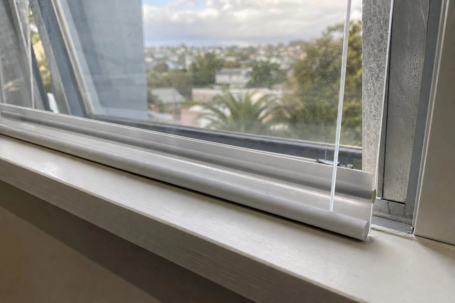 Illustrative: an acrylic panel on a magnetic strip fitted inside an older aluminium window