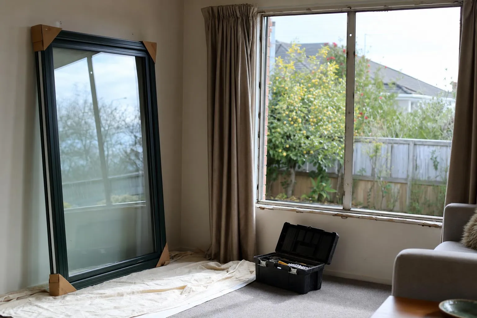 Illustrative: a new sealed double glazed unit with corner protectors leaning against the wall, ready to fit into an existing window