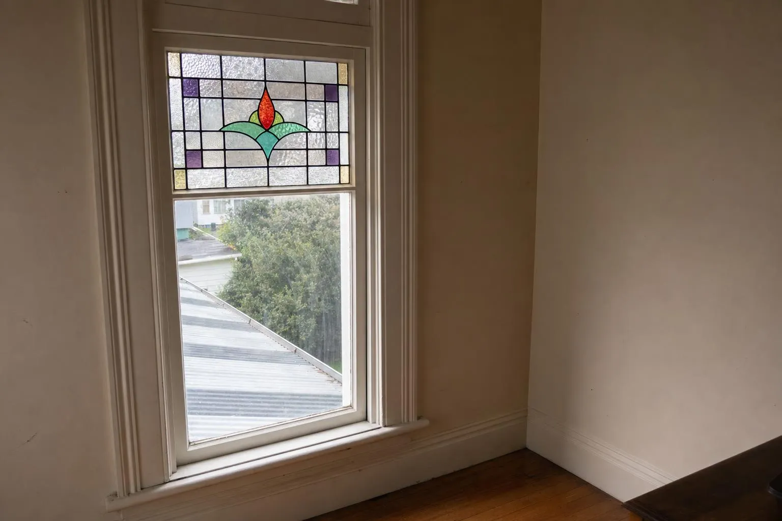 Illustrative: a villa window with a coloured leadlight panel in its upper section and plain glass below