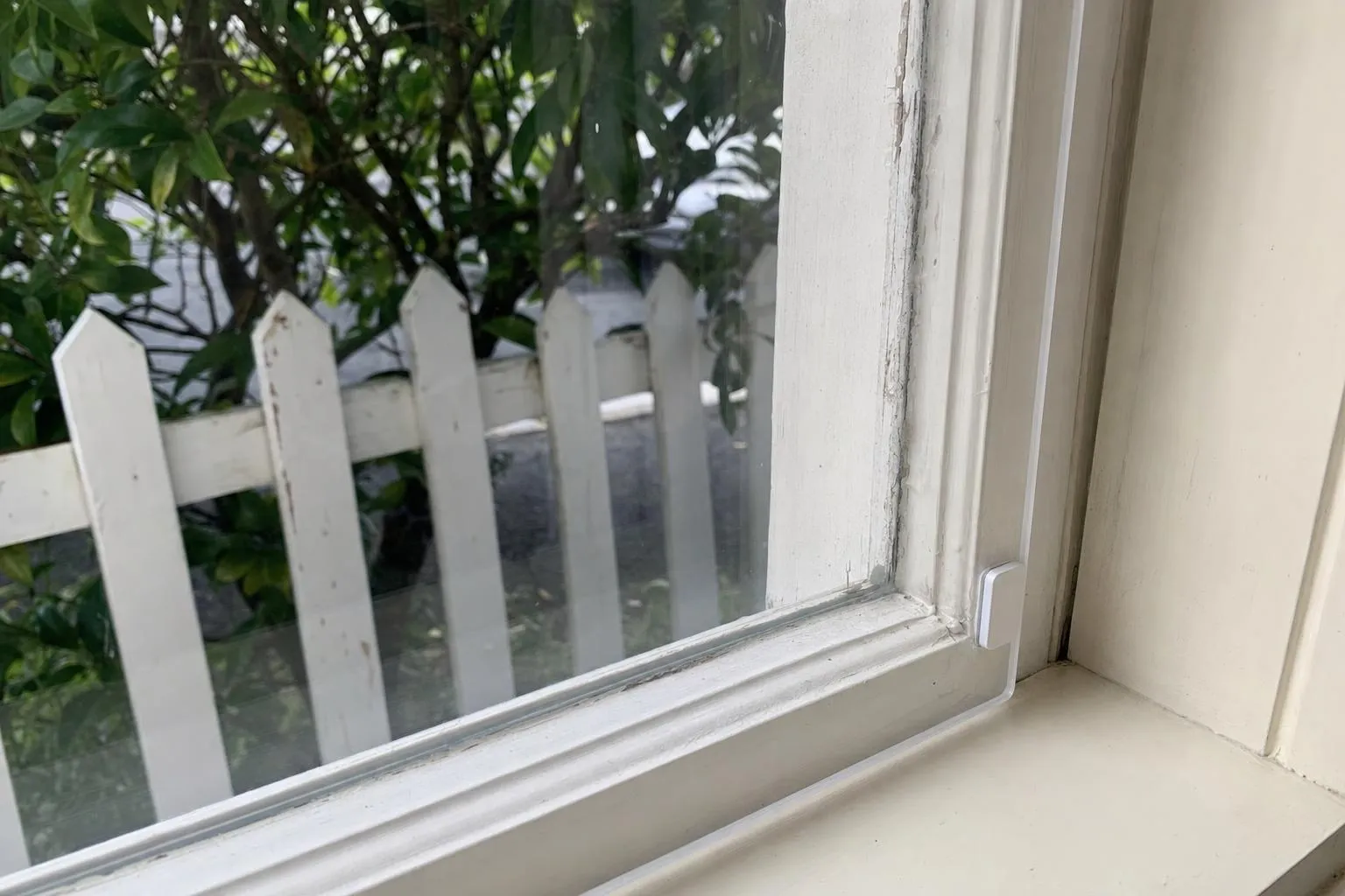 Illustrative: a clear acrylic secondary glazing panel on a magnetic strip fitted inside a painted timber sash